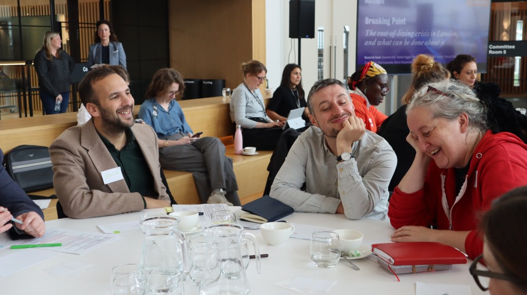 Zack Polanski AM engaging with participants at City Hall's cost of living crisis. Zack is seated on the lefthand side of the table. 