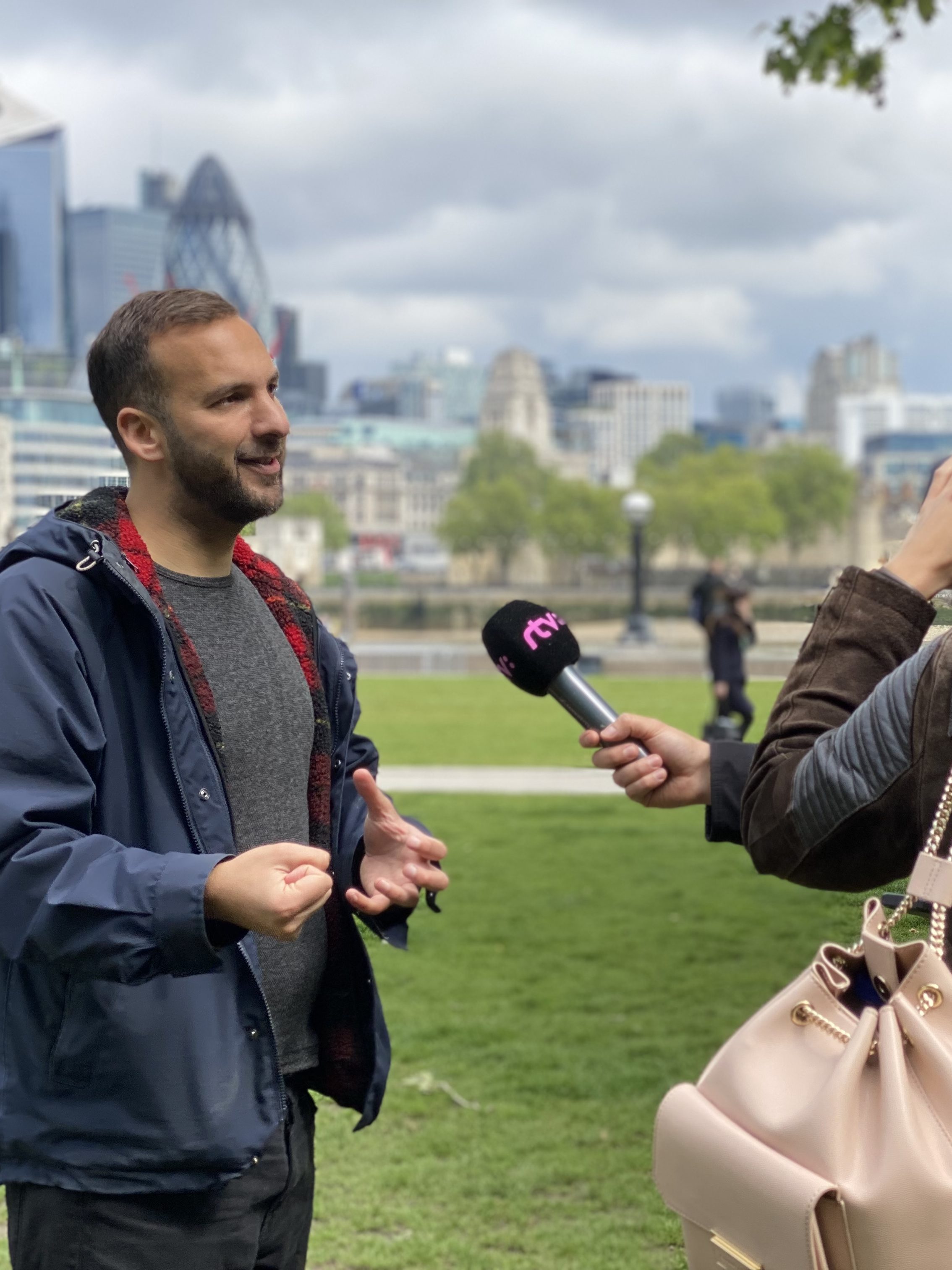 ZacK Polanski speaks to journalists while outside in London, with the Bank area of town visible behind him.
